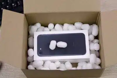iPhone mit Polstermaterial im Karton